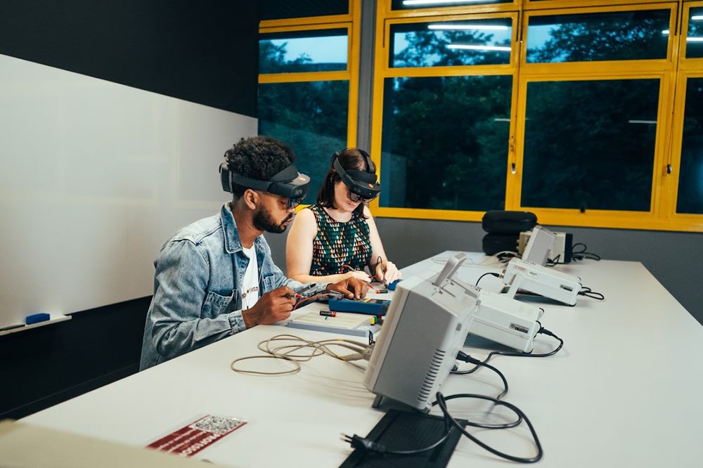 Dupla usando óculos de realidade virtual em bancada de laboratório