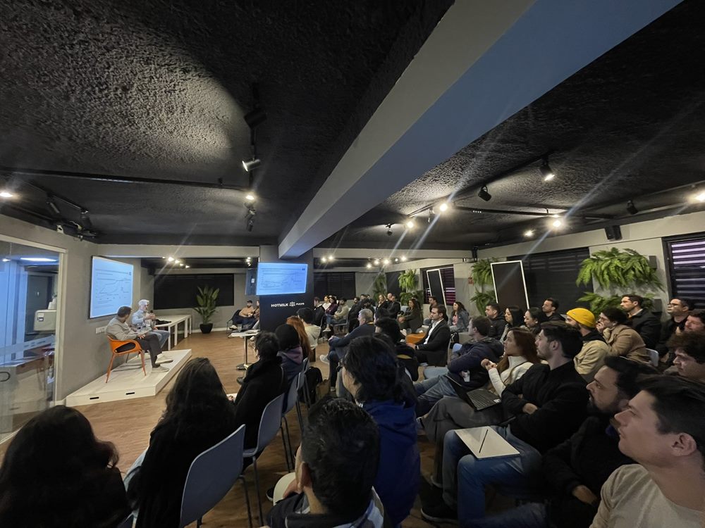 Plateia acompanhando um painel na arena de eventos da HOTMILK