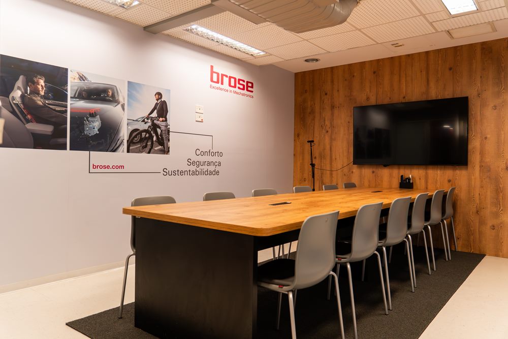 Sala empresarial da Brose no Hub, com mesa de reunião e TV
